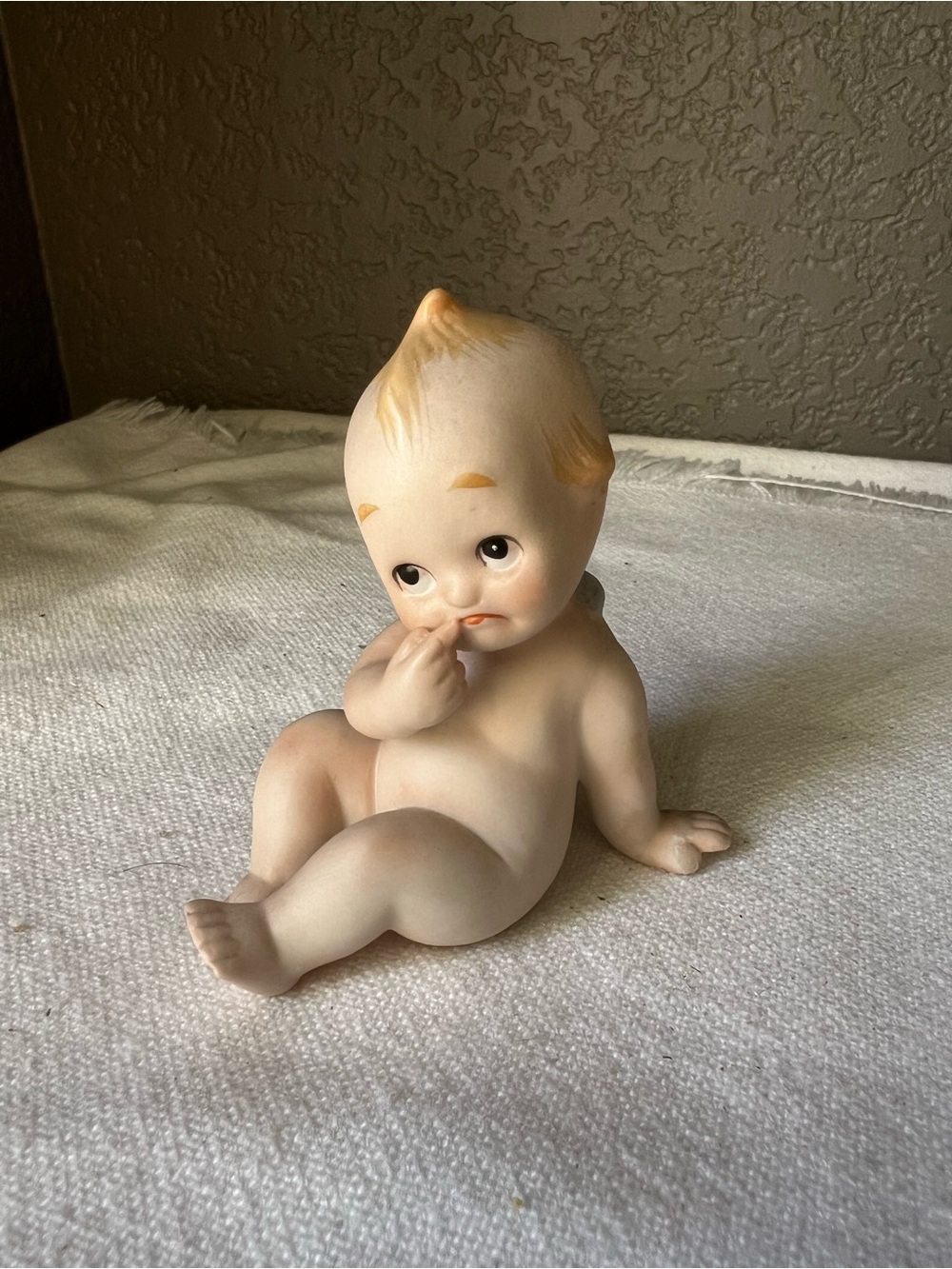 vintage Lefton Kewpie bisque porcelain figurine features a seated baby
Blue box